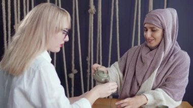 Çay bardakları ile masada iki kadın arkadaş.