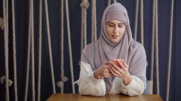 Счастливая мусульманка с помощью смартфона . — стоковое видео