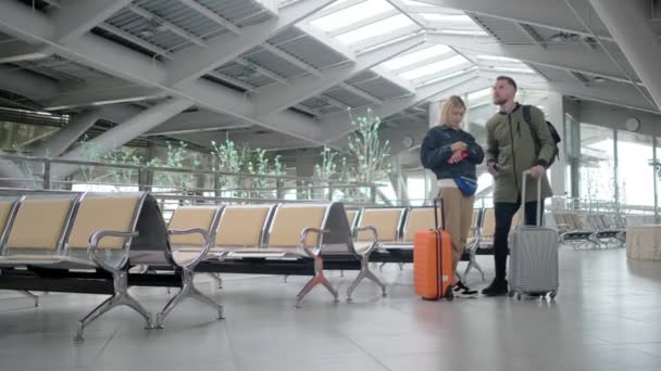 Married couple with suitcases are inside waiting hall of station in daytime — Stock Video