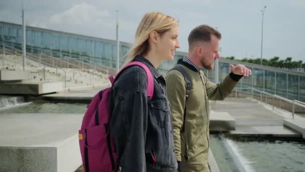 Mužští a ženský turisté chodí po příjezdu s zavazadly na slunné ulici — Stock video