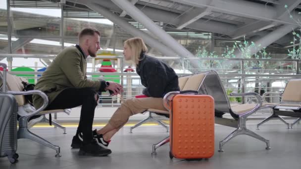 Pareja de amantes están esperando tren en la construcción de la estación de tren, charlando — Vídeo de stock