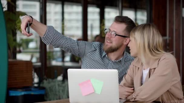 Pareja cariñosa está tomando selfie por la cámara del teléfono inteligente, sentado en la cafetería al aire libre — Vídeos de Stock