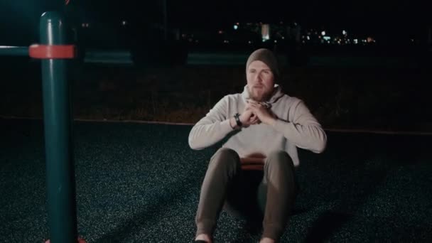 Knappe man is trainen buiten in de nacht, stijgende corpus van de grond — Stockvideo