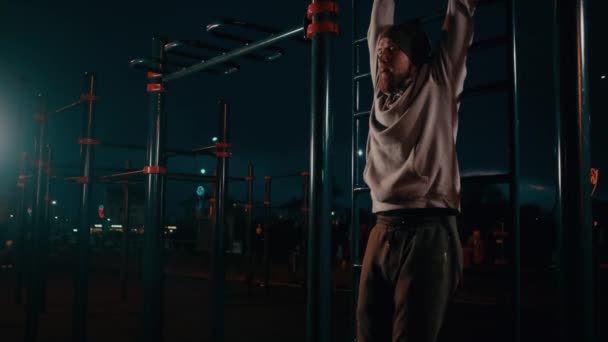 Мужчины-горожане тренируются в спортивной зоне городского парка ночью — стоковое видео