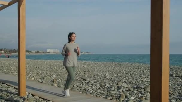 Mujer praciticing actividades deportivas en la orilla . — Vídeo de stock