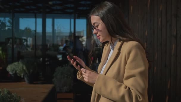 Schattig Urban meisje met smartphone van café. — Stockvideo