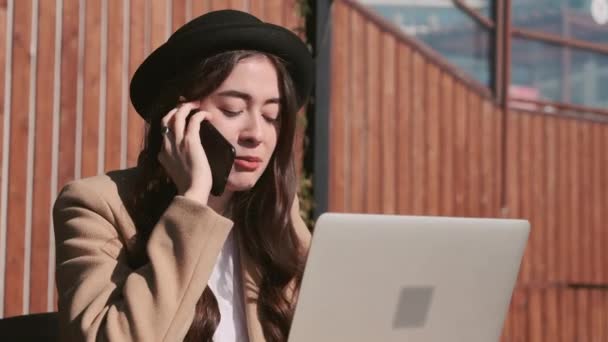 Joven blogger hablando por teléfono al aire libre . — Vídeos de Stock