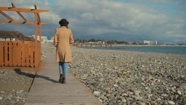 Chica tomando un paseo solitario en una playa . — Vídeo de stock