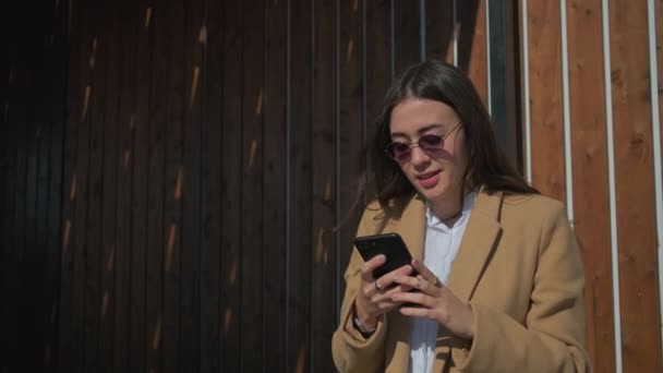 Mädchen SMS auf dem Smartphone im Freien. — Stockvideo