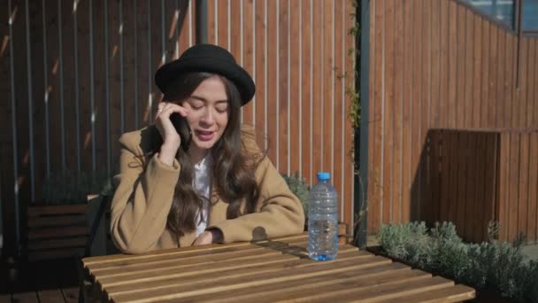 Bonita morena falando ao telefone em um parque . — Vídeo de Stock