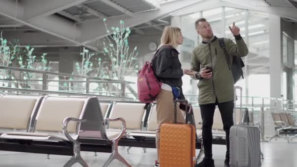 Man and woman casualy talking in airport. — Stock Video