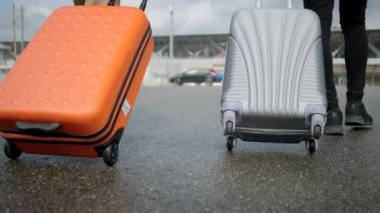 Kadın ve erkek bagajlarını yuvarlar.