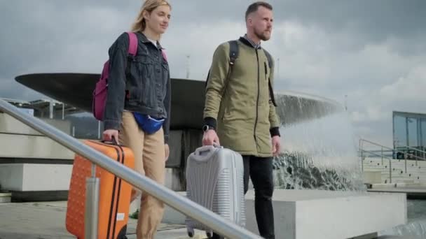 Jeune couple quittant l'aéroport avec bagages . — Video