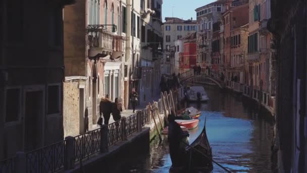 Italien, venedig, februar 2019. gondolier rudert langsam ein boot in einer engen kanalstraße in venedig. — Stockvideo