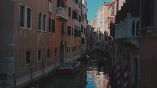 Itália, Veneza, fevereiro de 2019. Viagem europeia. Rua de canal estreito escuro com gandolas estacionadas junto aos edifícios . — Vídeo de Stock
