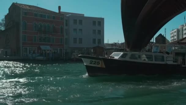Itália, Veneza, fevereiro de 2019. Barco de balsa passando sob a ponte cheia de pessoas locais . — Vídeo de Stock