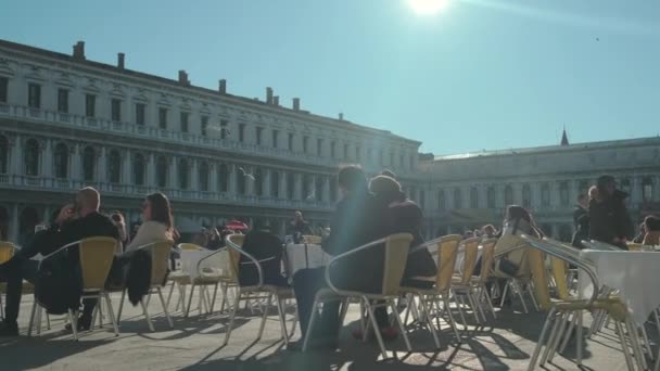 意大利,威尼斯,2019年2月。人们四处走动,在圣马可大教堂广场的露台上的咖啡馆里吃饭. — 图库视频影像