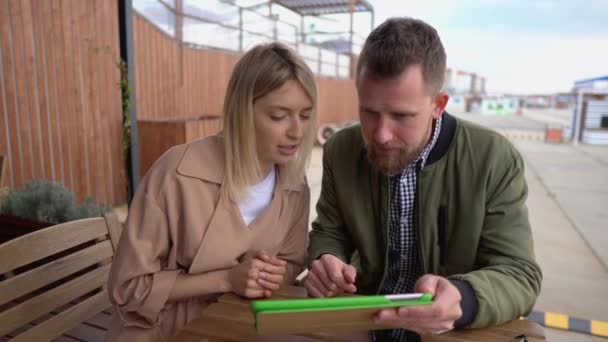 Homem e mulher falando sobre gadget ao ar livre . — Vídeo de Stock
