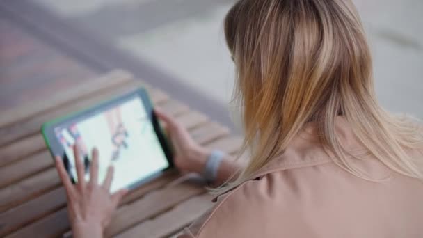 Vrouw met een gadget buiten. — Stockvideo