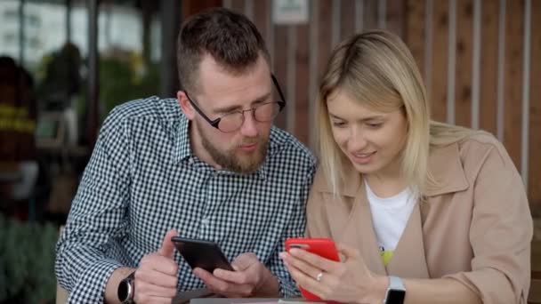 Pareja usando teléfono inteligente fuera — Vídeos de Stock