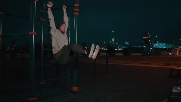 Guy gör benet höjer på en Sportsground. — Stockvideo