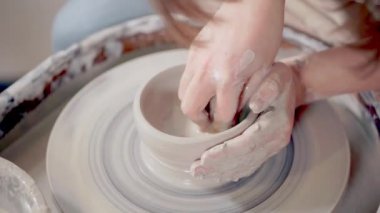Ceramist bir tekerlek üzerinde kil kupa heykel.