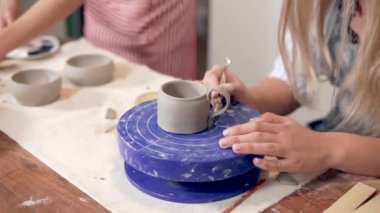 Stüdyoda seramik bardak yapan bir kadın..