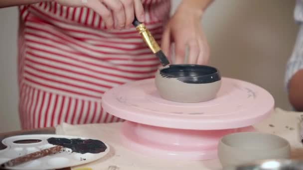 Donna sta dipingendo una tazza di ceramica in ceramica, stand rotante, primo piano — Video Stock