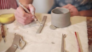 Kız sanat stüdyosunda bir kil fincan yapma.