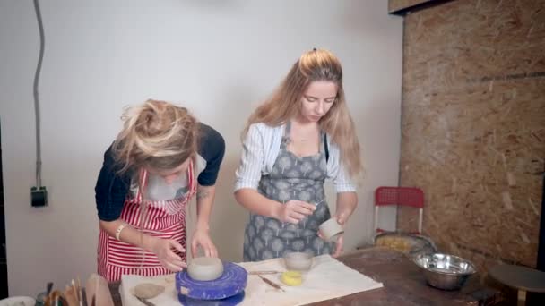 Deux jeunes femmes travaillent dans la poterie, faisant de la vaisselle en argile — Video