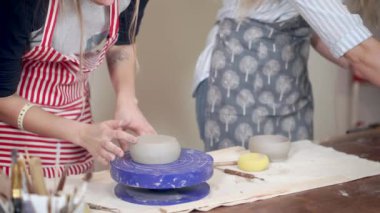 Çömlek atölyesinde seramik kapları modelalan dişi çömlekçiler, ellerin detay görünümü