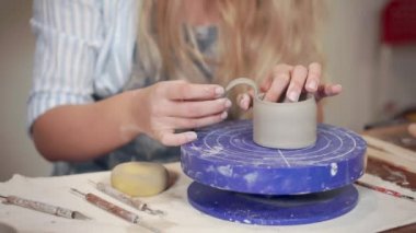 Ceramist kadın atölyede kil fincan için kolu sabitleme, yakın çekim