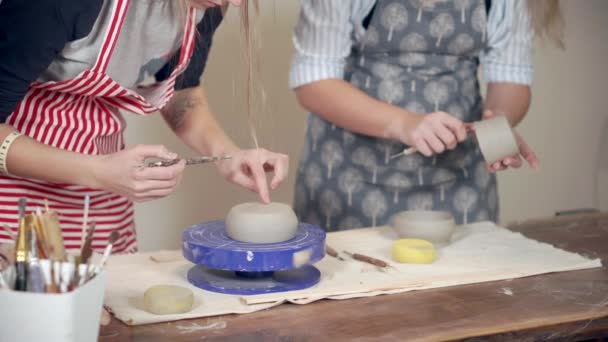 Две женщины-гончары обрабатывают керамические чаши в мастерской, крупным планом — стоковое видео
