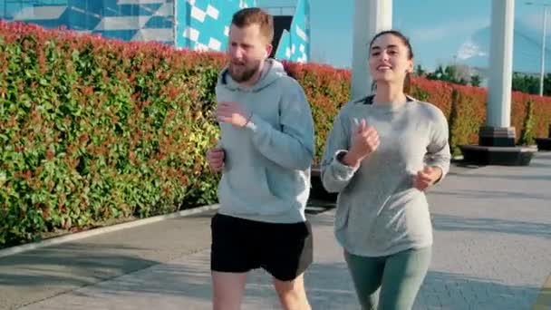 Amici maschi e femmine fanno jogging insieme all'aria aperta al mattino, vista frontale — Video Stock