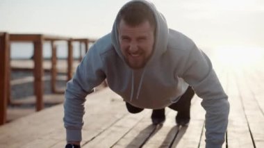 Güçlü adam güneşli sabahları dışarıda şınav çekiyor.