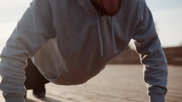 Sportsman está haciendo flexiones en la calle durante el entrenamiento de la mañana — Vídeo de stock