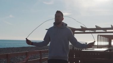 Deniz manzarasına karşı deniz plajında ip adam atlama silueti