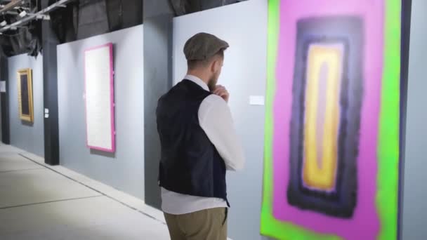 Visitante masculino de exposición de artista abstracto moderno está viendo la imagen — Vídeos de Stock