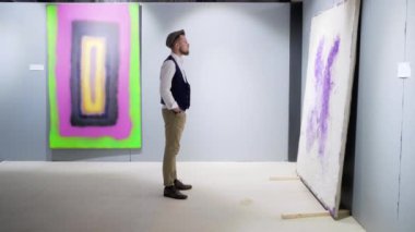 Yalnız adam müze salonunda soyut sanat görüntüleme