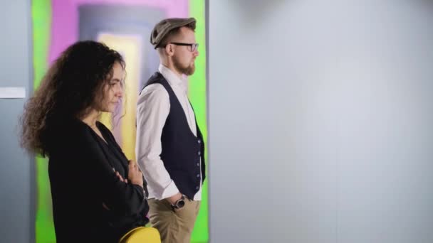 Uomo e donna detestano l'immagine astratta moderna nella galleria d'arte, mentre se ne vanno — Video Stock