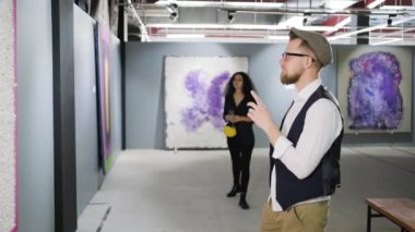 Modern sanat galerisierkek ziyaretçi resim leniyor, kadın yaklaşıyor
