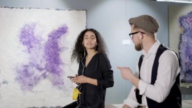 Erkek ve kadın modern sanat galerisi ziyaret ve kulaklık la müzik dinliyor