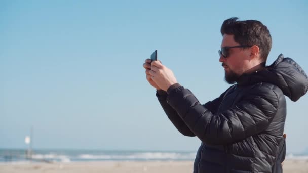 El hombre está fotografiando paisajes marinos por teléfono móvil — Vídeos de Stock