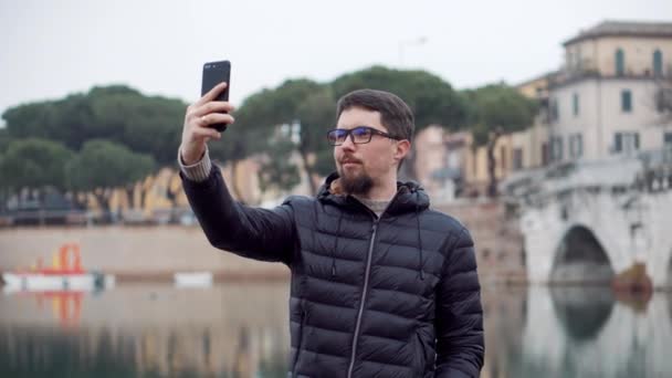 El hombre se está tomando selfies por teléfono móvil con puntos de referencia — Vídeo de stock