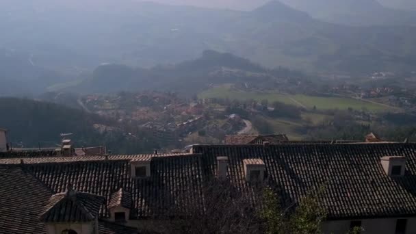 Вид сверху на ландшафт с небольшой деревушкой в горах — стоковое видео