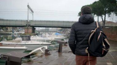 Adam Via destra del port boyunca yürüyor