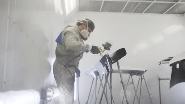 Master colore les pièces métalliques de l'automobile dans une cabine de peinture . — Video