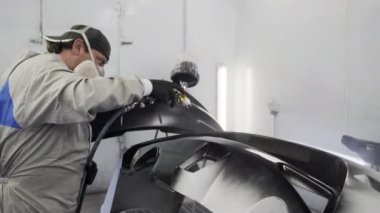 Araba ressamı oto servis merkezinin boya odasında tek başına çalışıyor