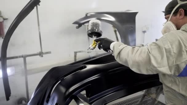 Adam araba fabrikasının boyama atölyesinde çalışıyor, boyama detayları — Stok video