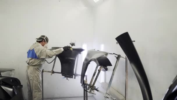 Живописні роботи в фарборозпилювальній кабіні автосервісу, чоловік працівник — стокове відео